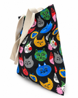 A colorful cat face tote bag filled with items, shown from the side to highlight its roomy shape and carrying capacity.