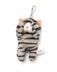 A gray tabby cat plush charm with its paws covering its eyes, a white muzzle, pink inner ears, and a pink nose, attached to a silver ball chain.