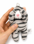 A gray tabby cat plush charm with a silver ball chain, held in a person's hand to show its size.