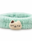 Soft and fluffy mint green spa headband with a cream cat face appliqué in the center.