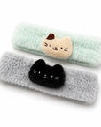 Soft and fluffy cat spa headbands in mint green with a cream cat and soft gray with a black cat.