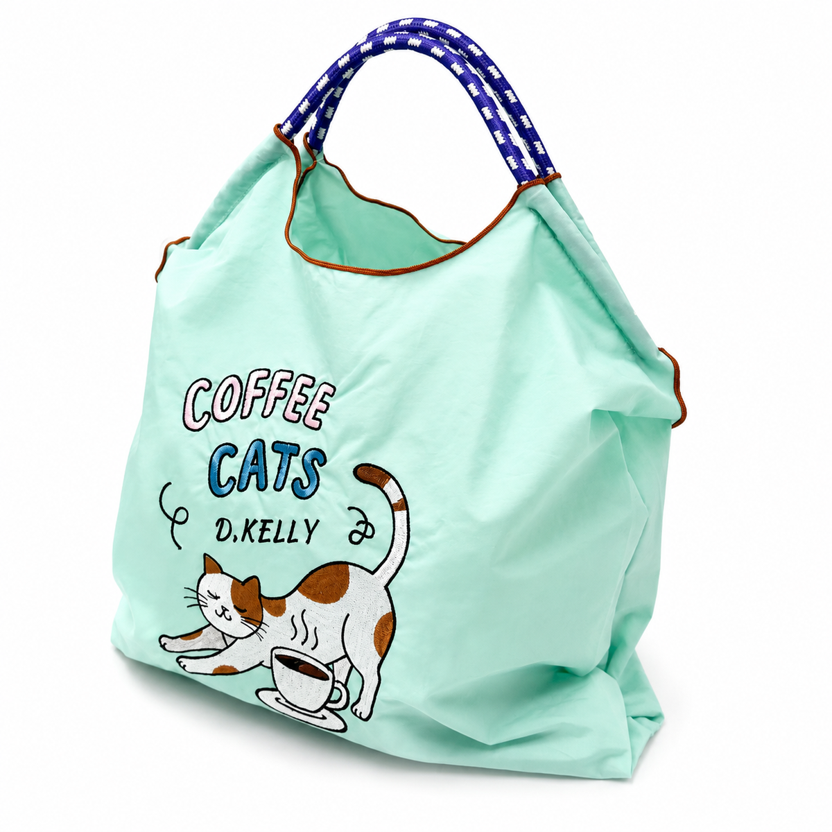 Angled view of a mint green Coffee Cats tote bag filled with items, featuring a stretching cat, coffee cup, and blue and white rope-style handles.