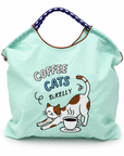 Mint green Coffee Cats tote bag filled with items, showing its roomy shape and embroidered cat and coffee cup design.