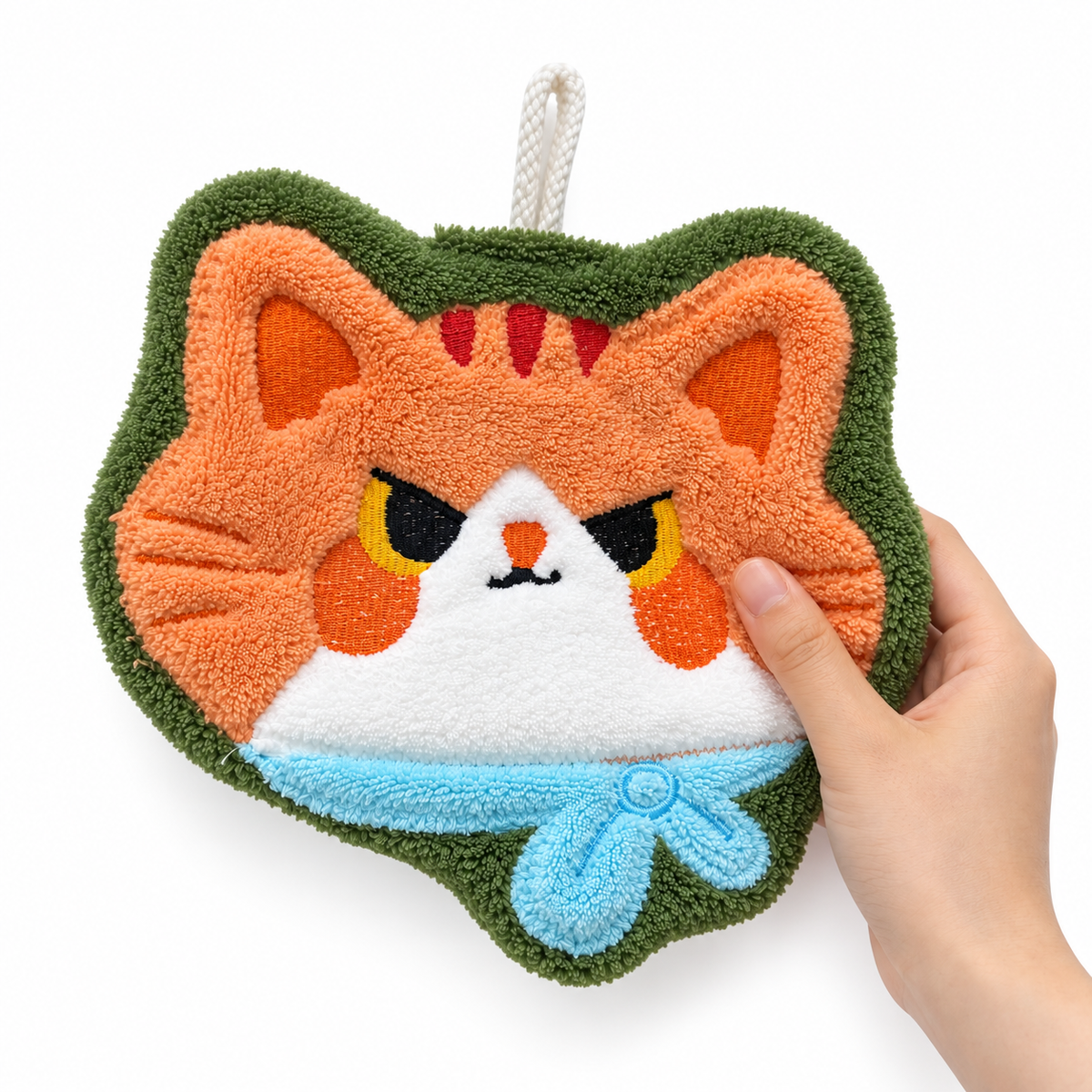 Hand touching the orange cat-face-shaped hand towel, showing its soft texture.
